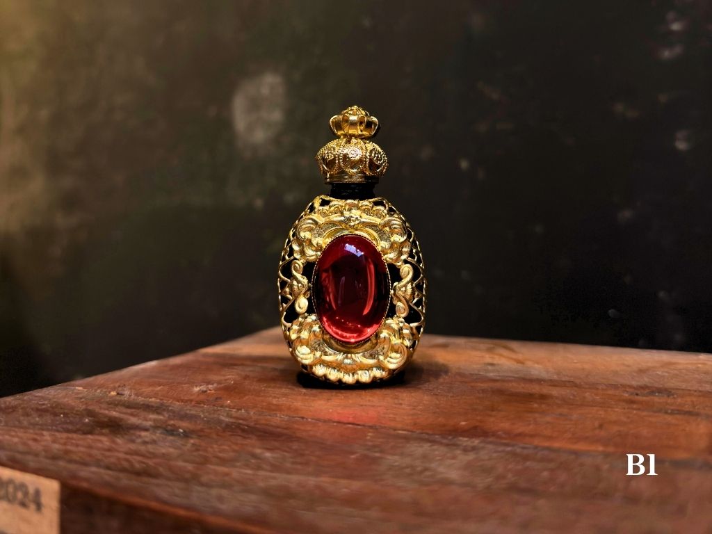Decorative gold and red object on a wooden surface with a dark background