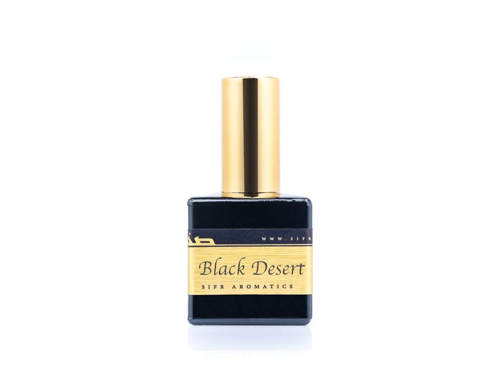 50ml spray bottle of Eau De Parfum placed elegantly on a white background. The bottle is sleek and black, with a polished gold cap. The label on the bottle is designed in gold and black, featuring Sifr Aromatics' logo and the perfume name 'Black Desert' The overall aesthetic is clean and sophisticated, highlighting the high-quality craftsmanship of the product