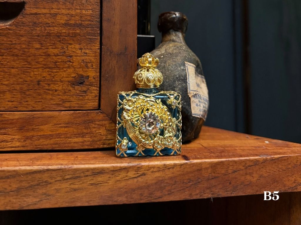 Decorative oil perfume bottle with gold and blue design. Silver gems and gold metal work