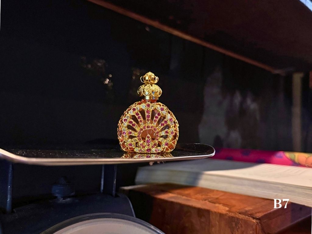 Handmade gold and pink decorative oil perfume bottle with pink and gold gemstone design 