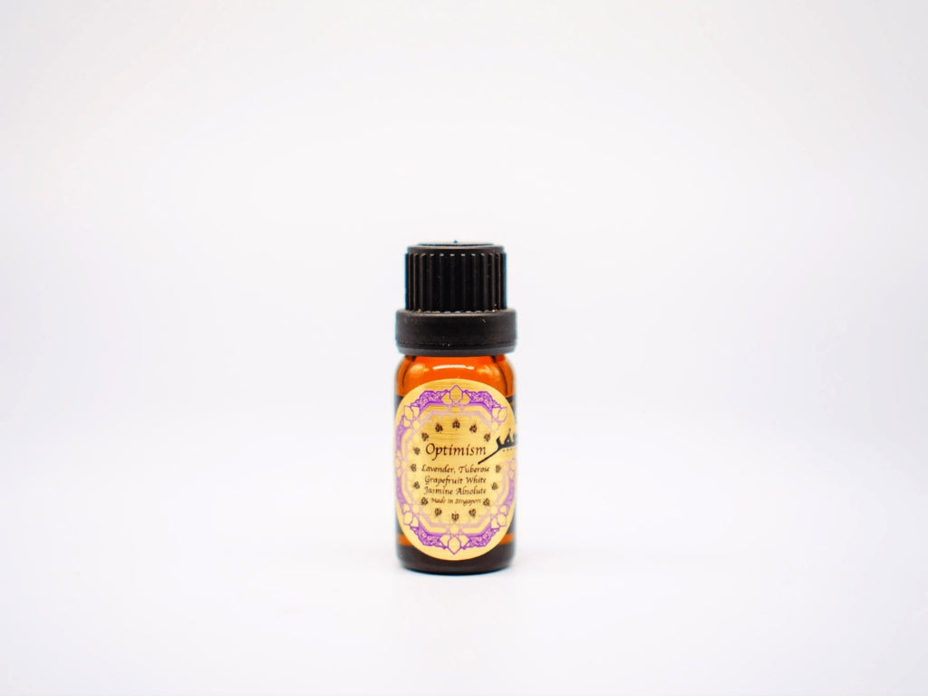 10ml bottle of Optimism Essential Oil Blend by Sifr Aromatics, featuring a gold label with ingredients listed; a luxurious floral blend of tuberose and jasmine in a glass bottle