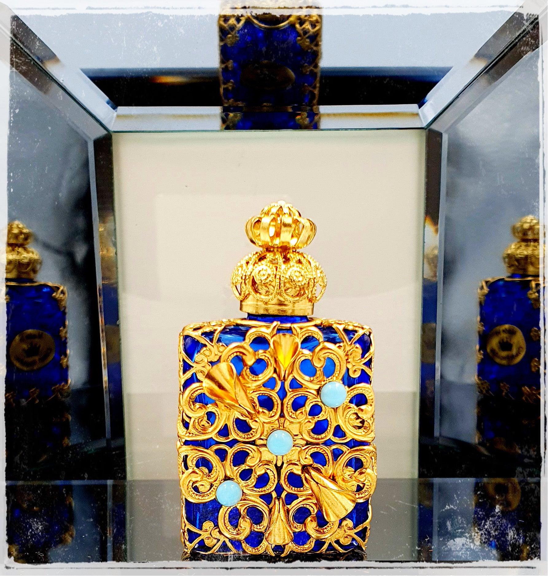 Ornate handmade Czech glass flacons crafted in the Jizera Mountains, featuring glass, brass, and colorful jewels. The bottles shine with gold and vibrant gems, perfect for holding oil perfumes