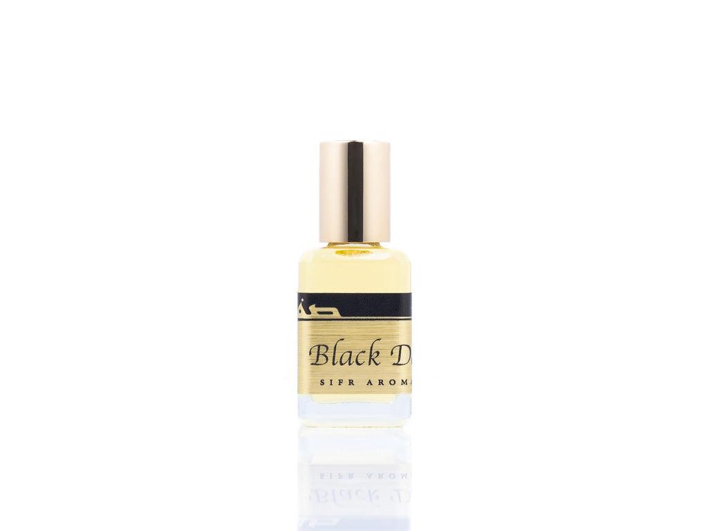 15ml roller ball oil perfume bottle placed elegantly on a white background. The bottle is sleek and cylindrical, with a smooth glass body and a polished metal roller ball at the top. The label on the bottle is designed in gold and black, featuring Sifr Aromatics' logo and the perfume name 'Black Desert.' The overall aesthetic is clean and sophisticated, highlighting the high-quality craftsmanship of the product