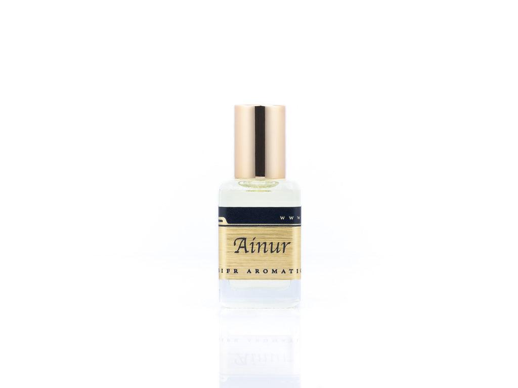 15ml roller ball oil perfume bottle placed elegantly on a white background. The bottle is sleek and cylindrical, with a smooth glass body and a polished metal roller ball at the top. The label on the bottle is designed in gold and black, featuring Sifr Aromatics' logo and the perfume name 'Ainur.' The overall aesthetic is clean and sophisticated, highlighting the high-quality craftsmanship of the product.