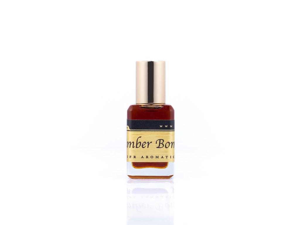 15ml roller ball oil perfume bottle placed elegantly on a white background. The bottle is sleek and cylindrical, with a smooth glass body and a polished metal roller ball at the top. The label on the bottle is designed in gold and black, featuring Sifr Aromatics' logo and the perfume name 'Amber Bomb.' The overall aesthetic is clean and sophisticated, highlighting the high-quality craftsmanship of the product.